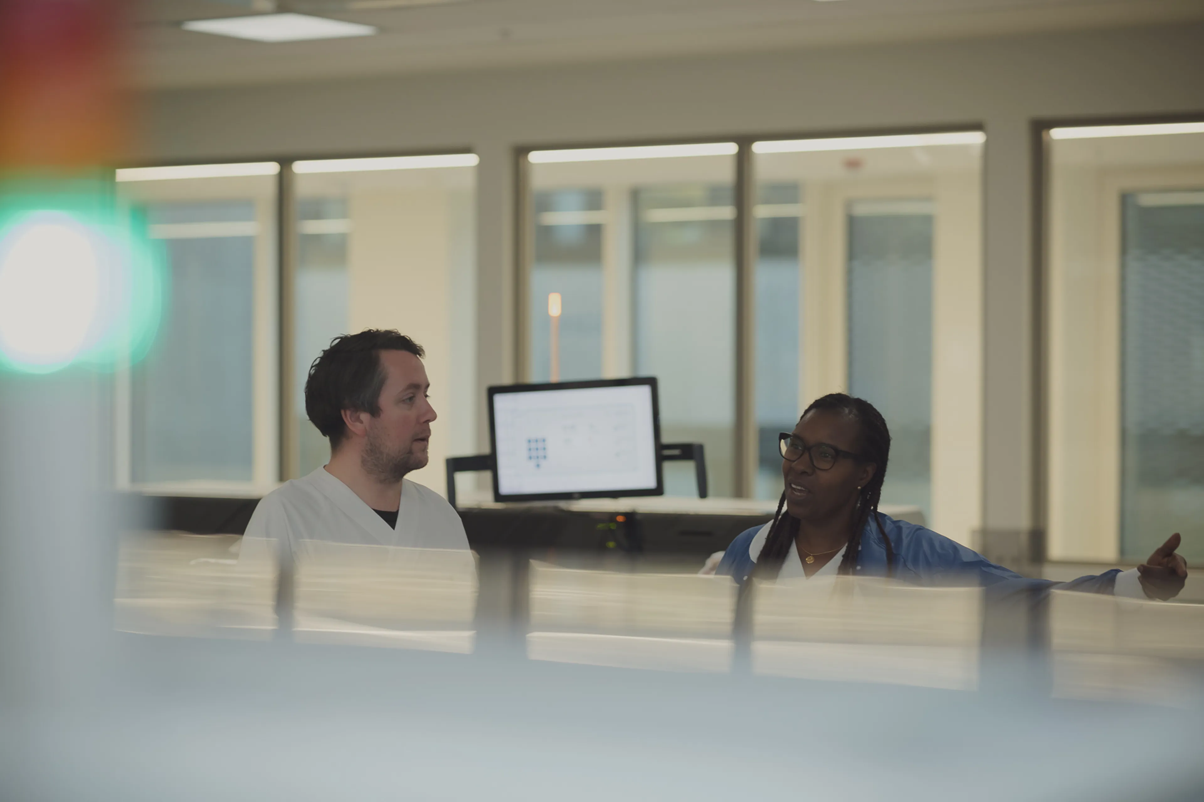 En mann og en kvinne sitter ved et bord og ser på en datamaskin