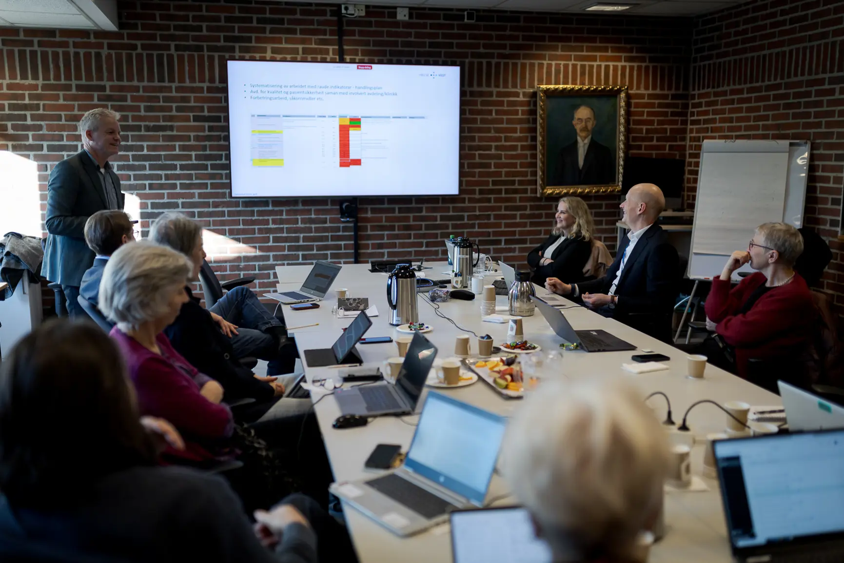 En gruppe mennesker som sitter rundt et bord med bærbare datamaskiner