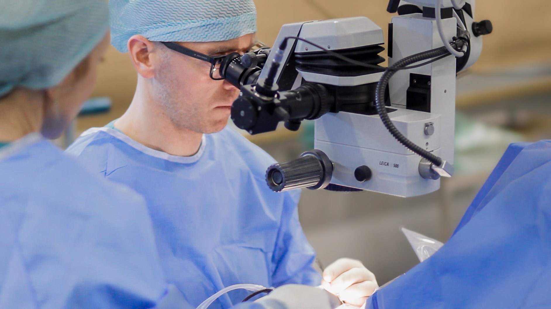 A man wearing a mask and a mask looking through a microscope