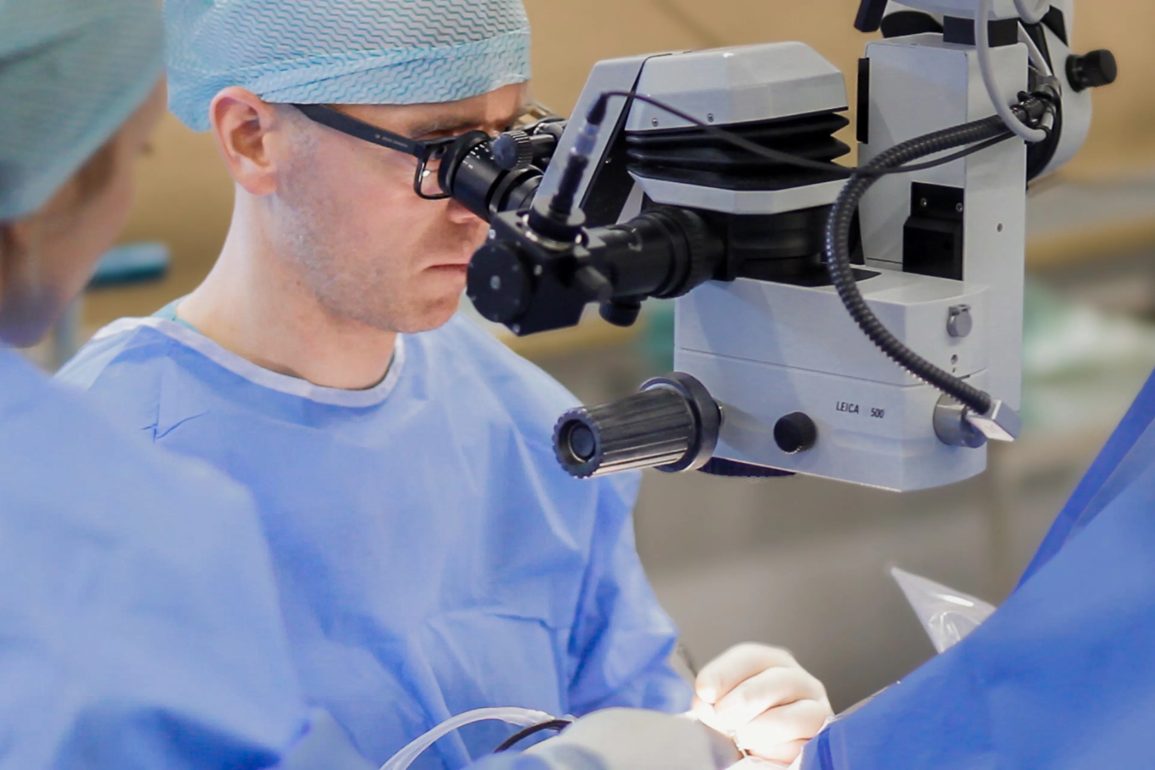 A man wearing a mask and a mask looking through a microscope
