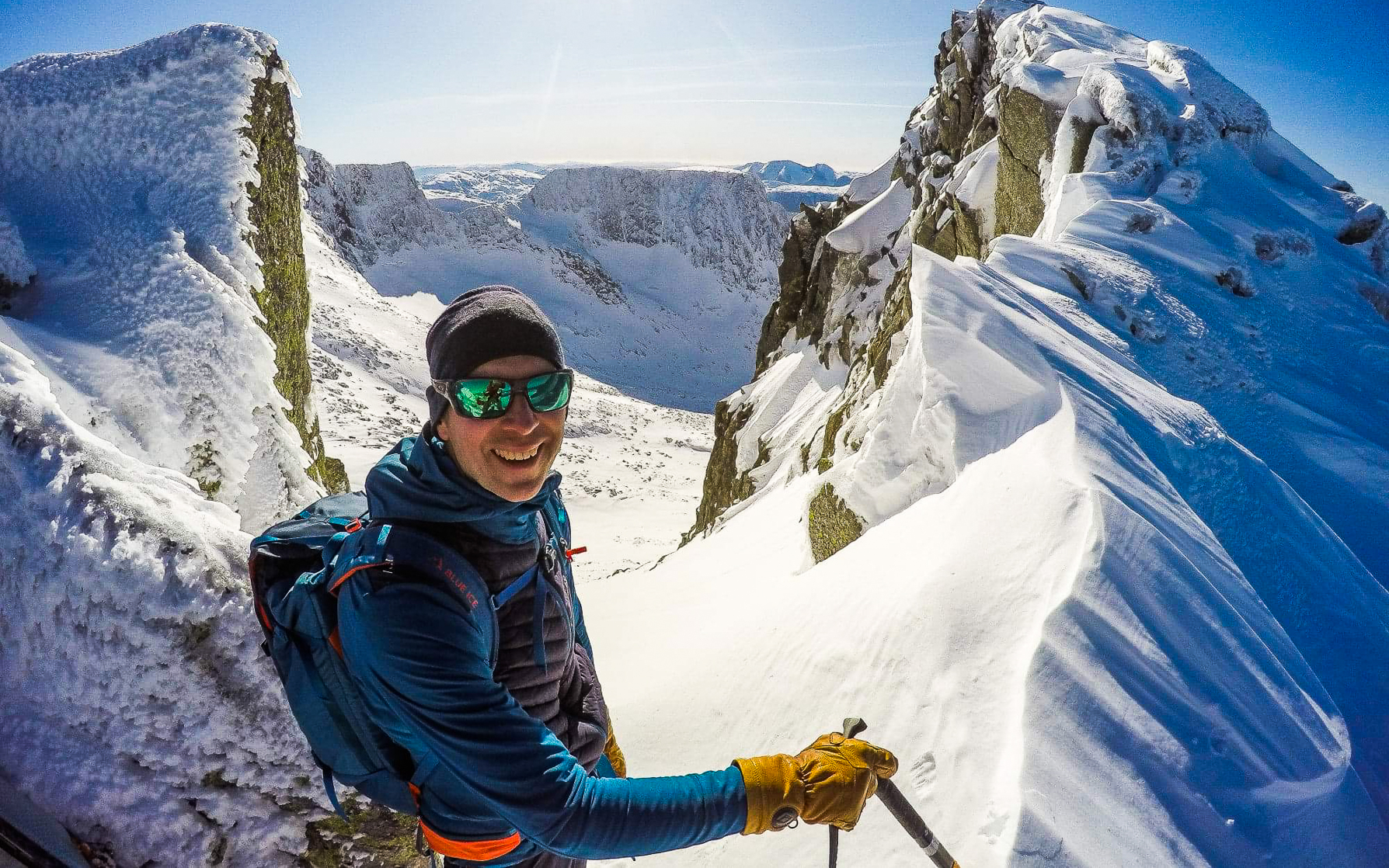 A man wearing sunglasses and a hat on a snowy mountain