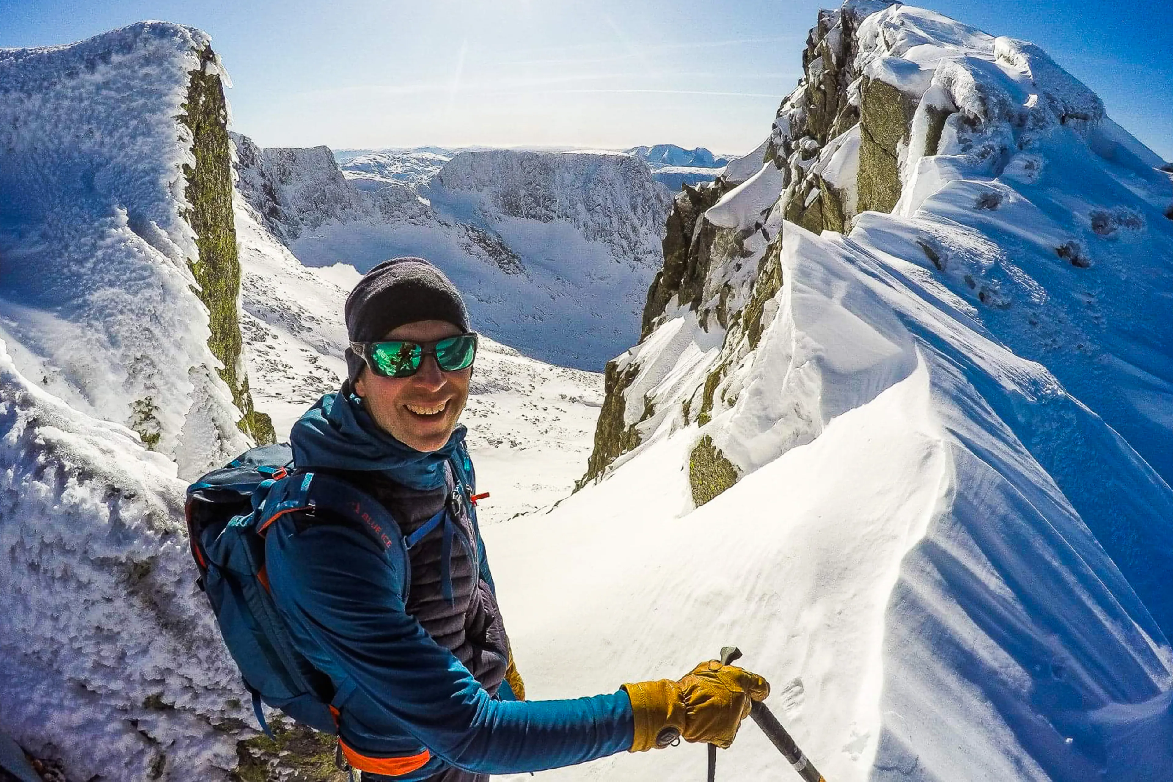 A man wearing sunglasses and a hat on a snowy mountain