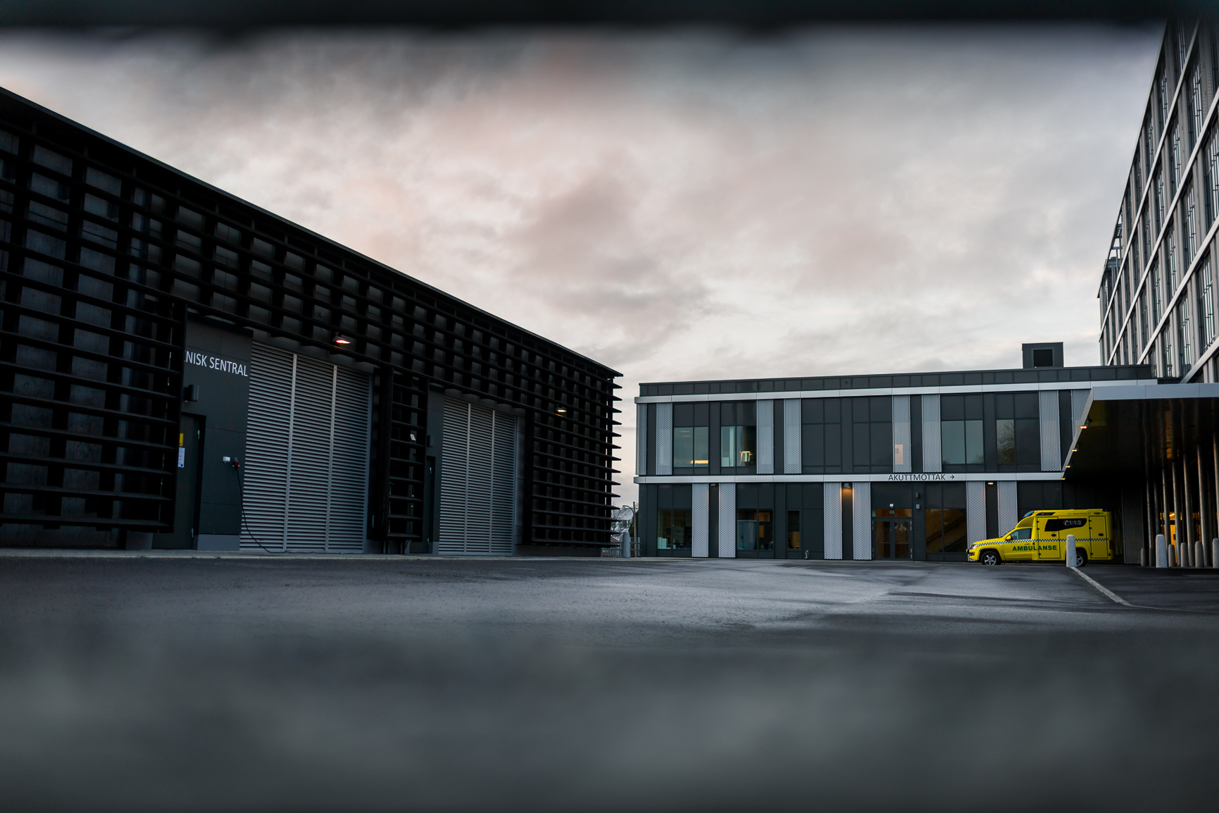 A building with a yellow ambulance parked in front of it