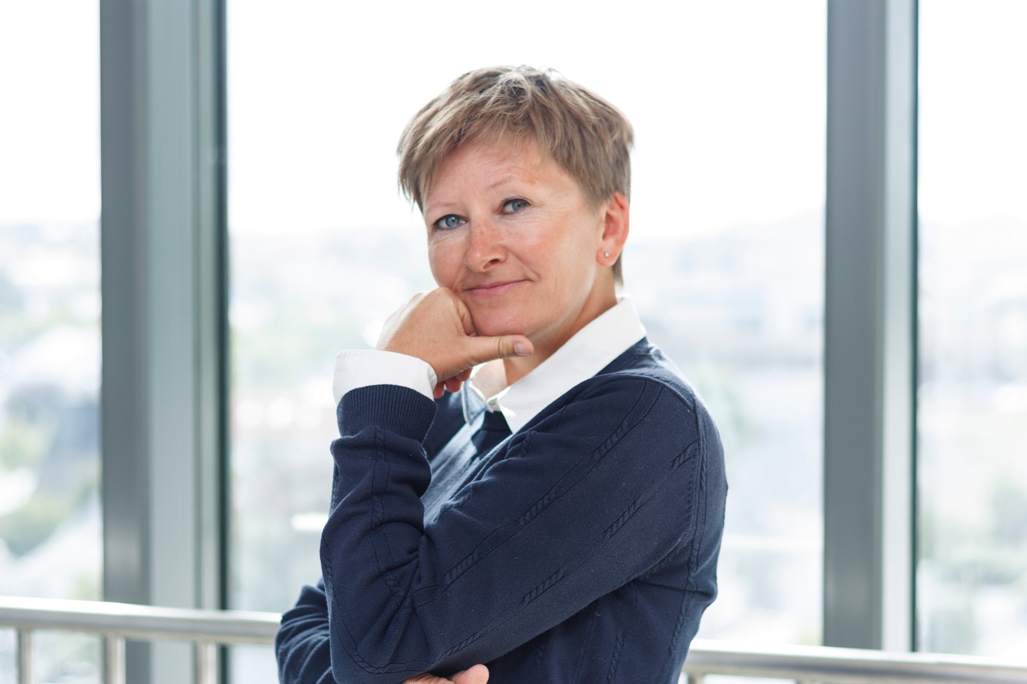 En dame som lener seg på et rekkverk