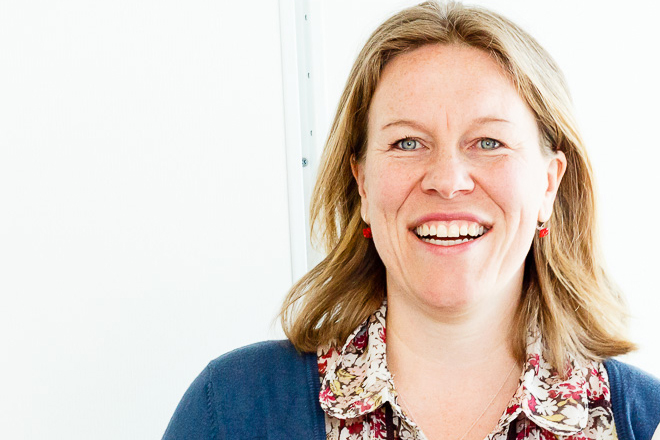 En kvinne som smiler til kameraet