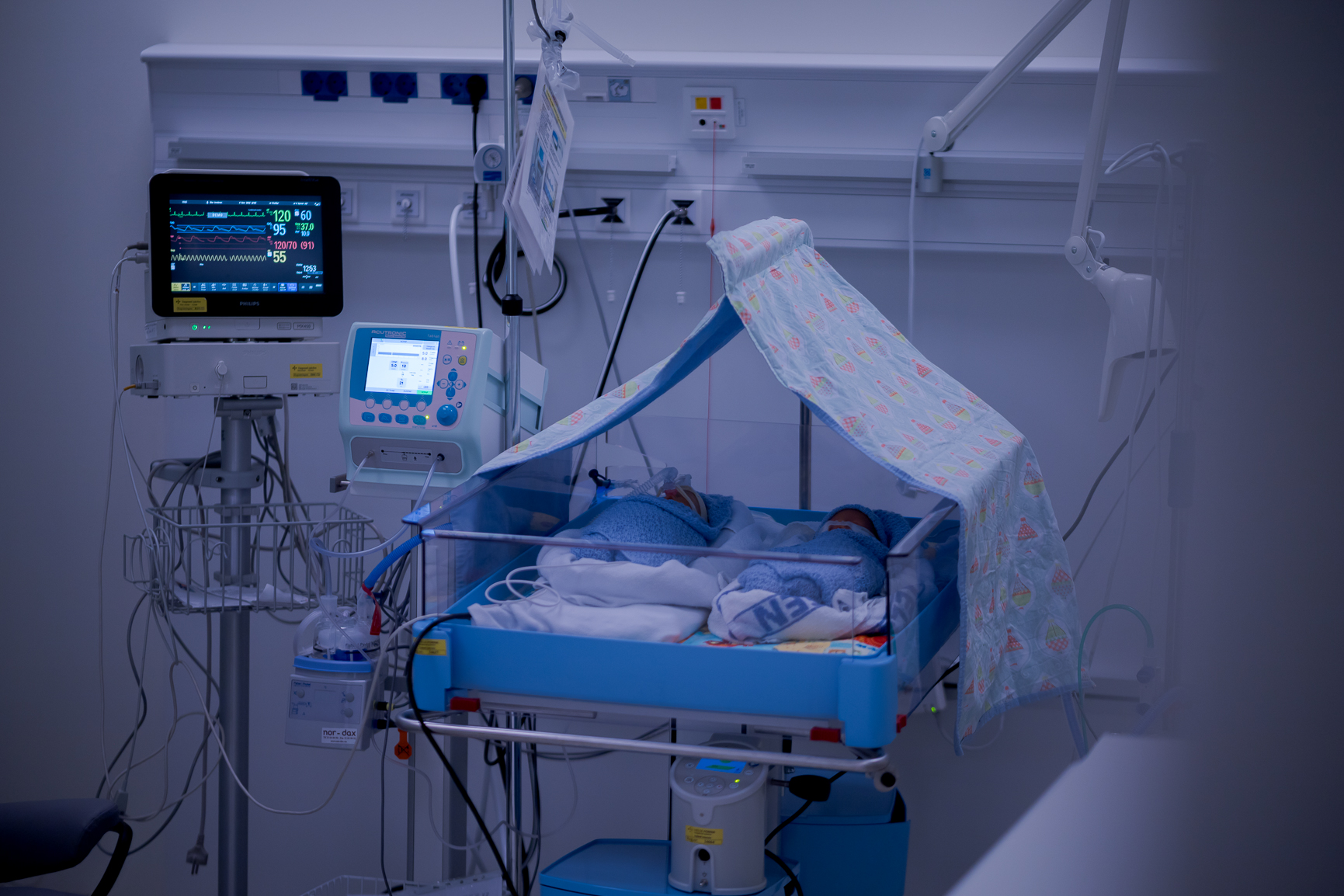 En sykehusseng med skjerm og medisinsk utstyr