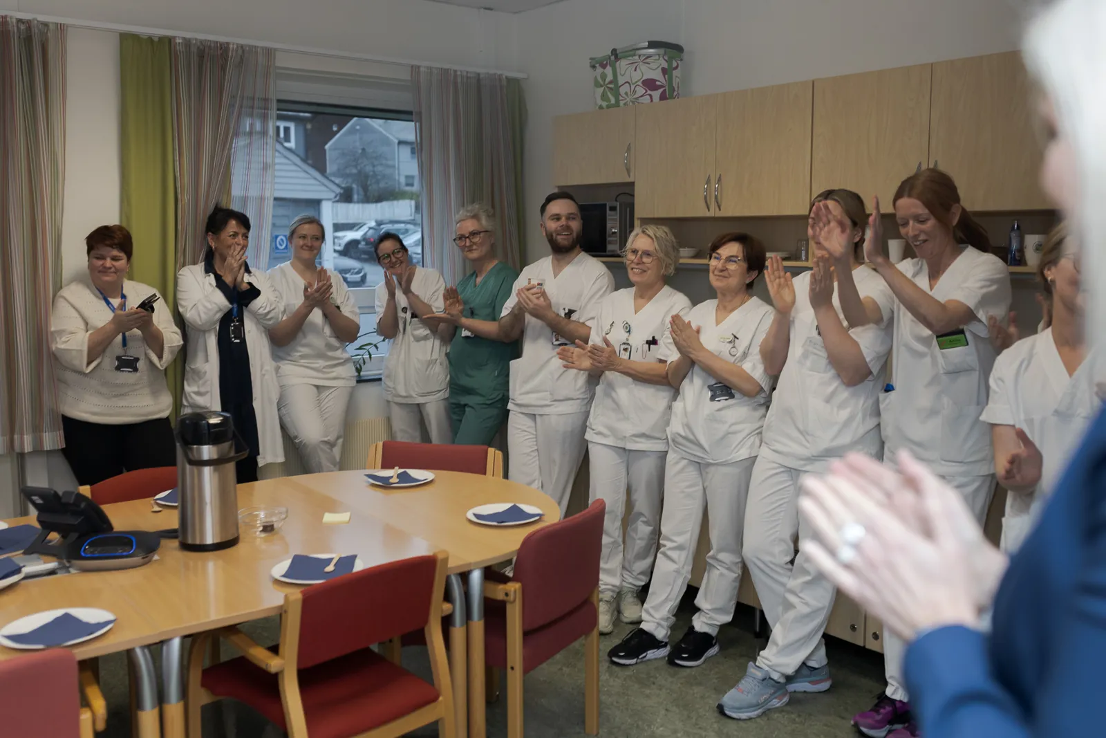 Ei gruppe sjukehuspersonell i eit rom