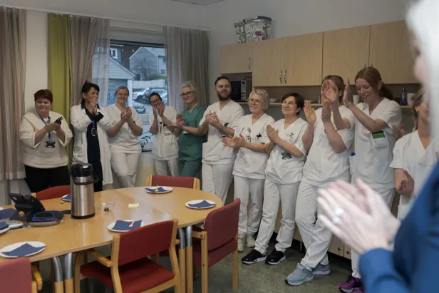 Ei gruppe sjukehuspersonell i eit rom