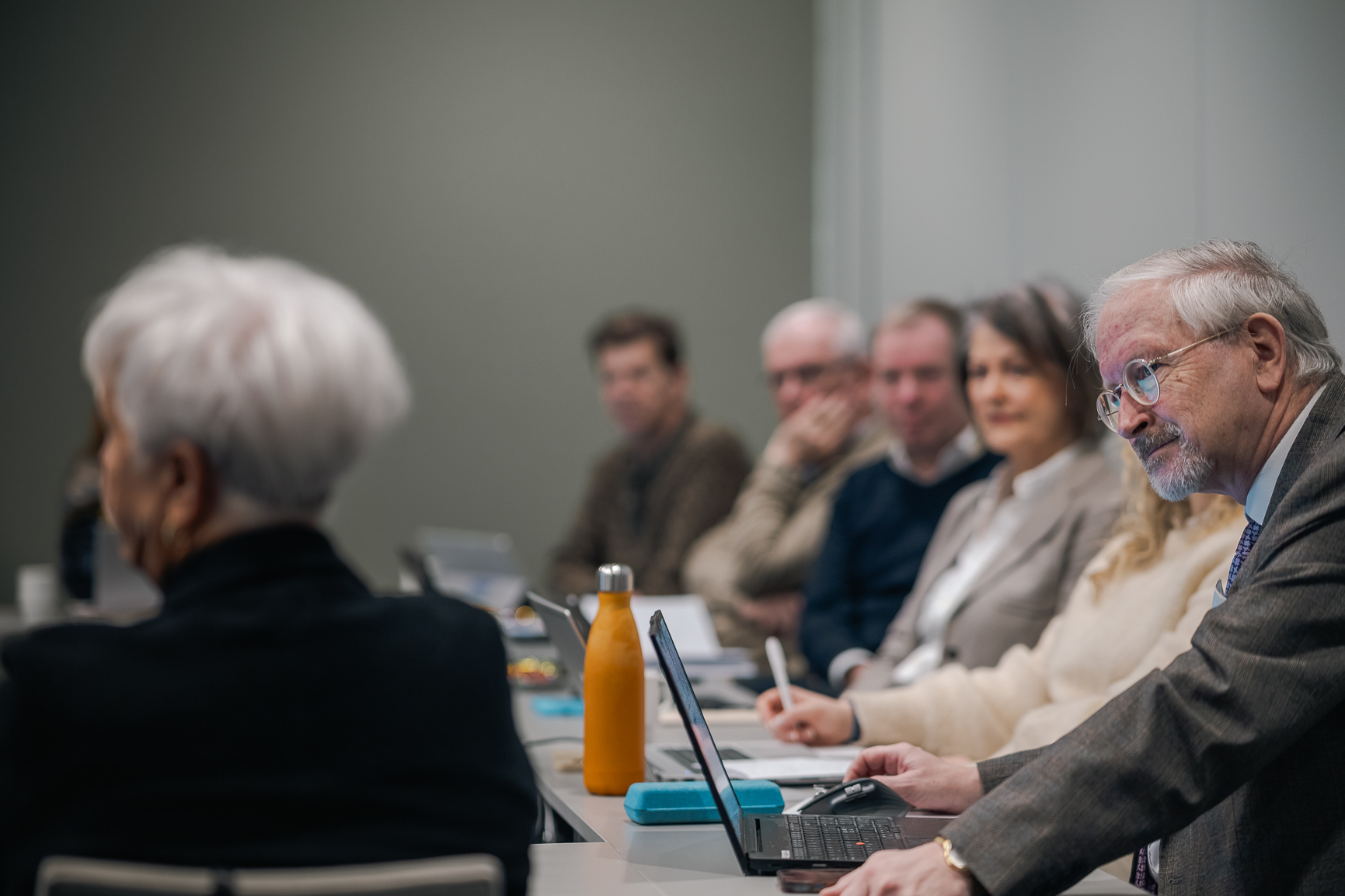 En gruppe mennesker som sitter ved et bord og ser på en bærbar PC