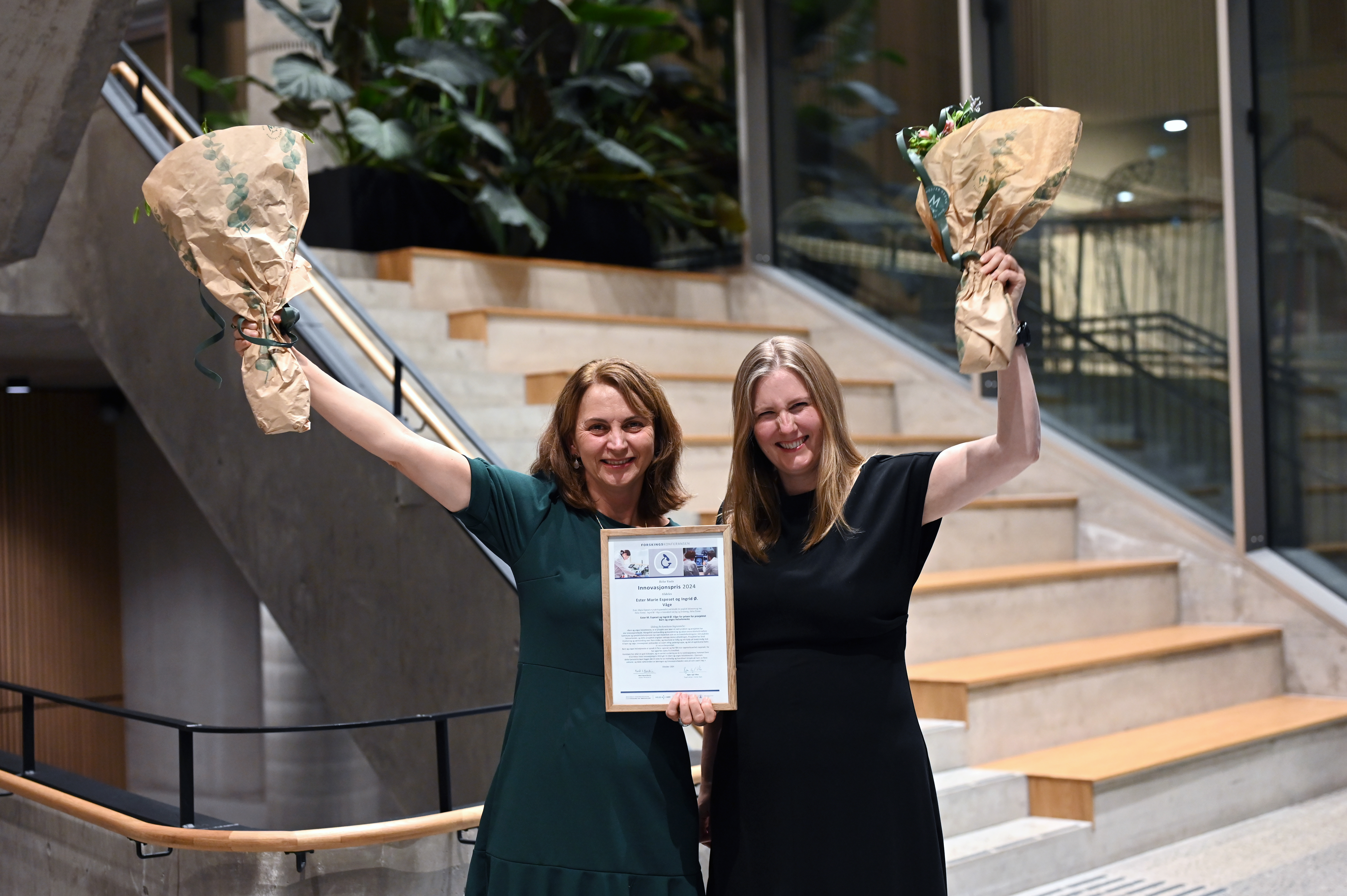 To damer som held blomsterbukettar og ein plakat