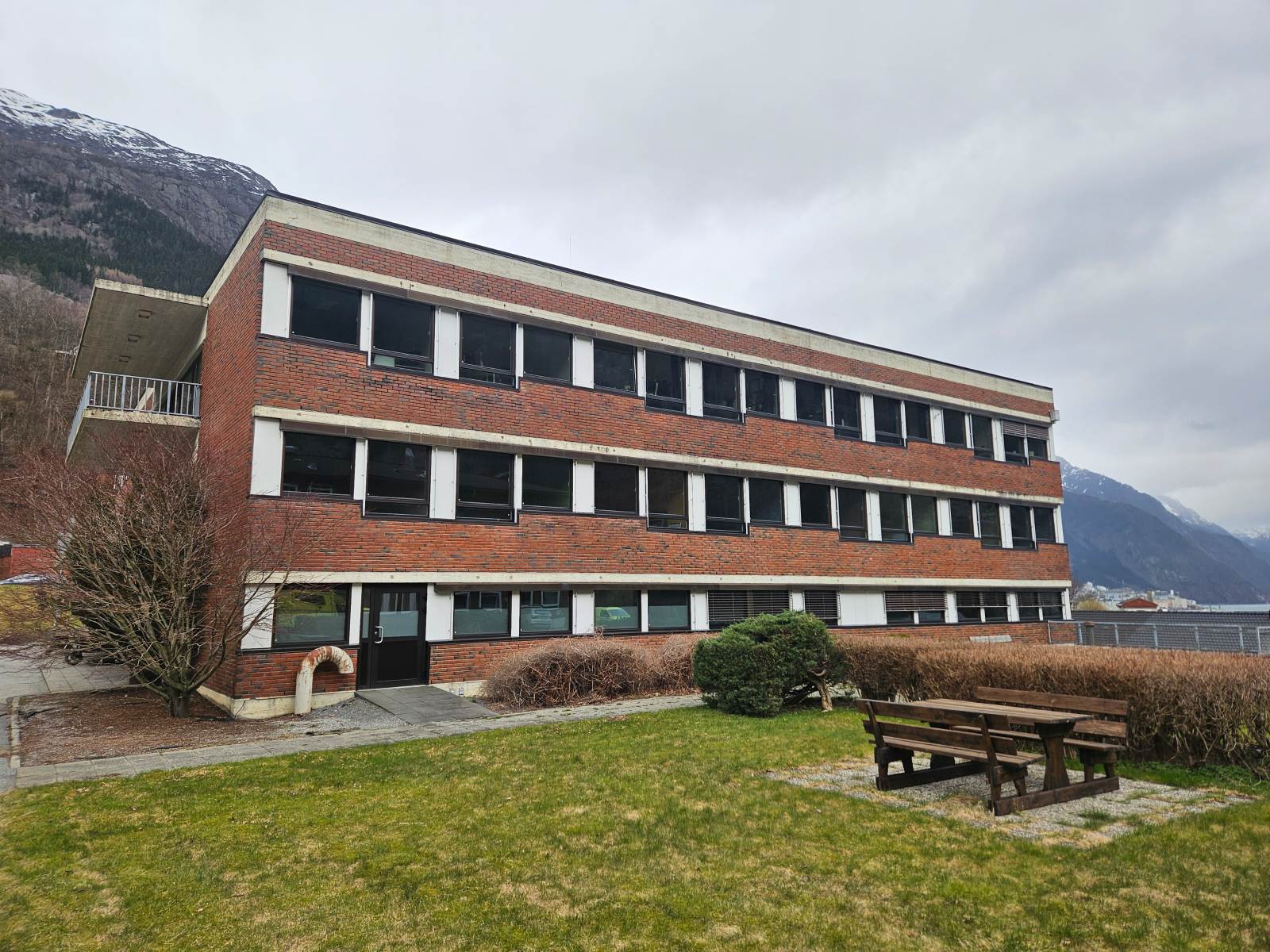 Ein bygning med ein benk foran