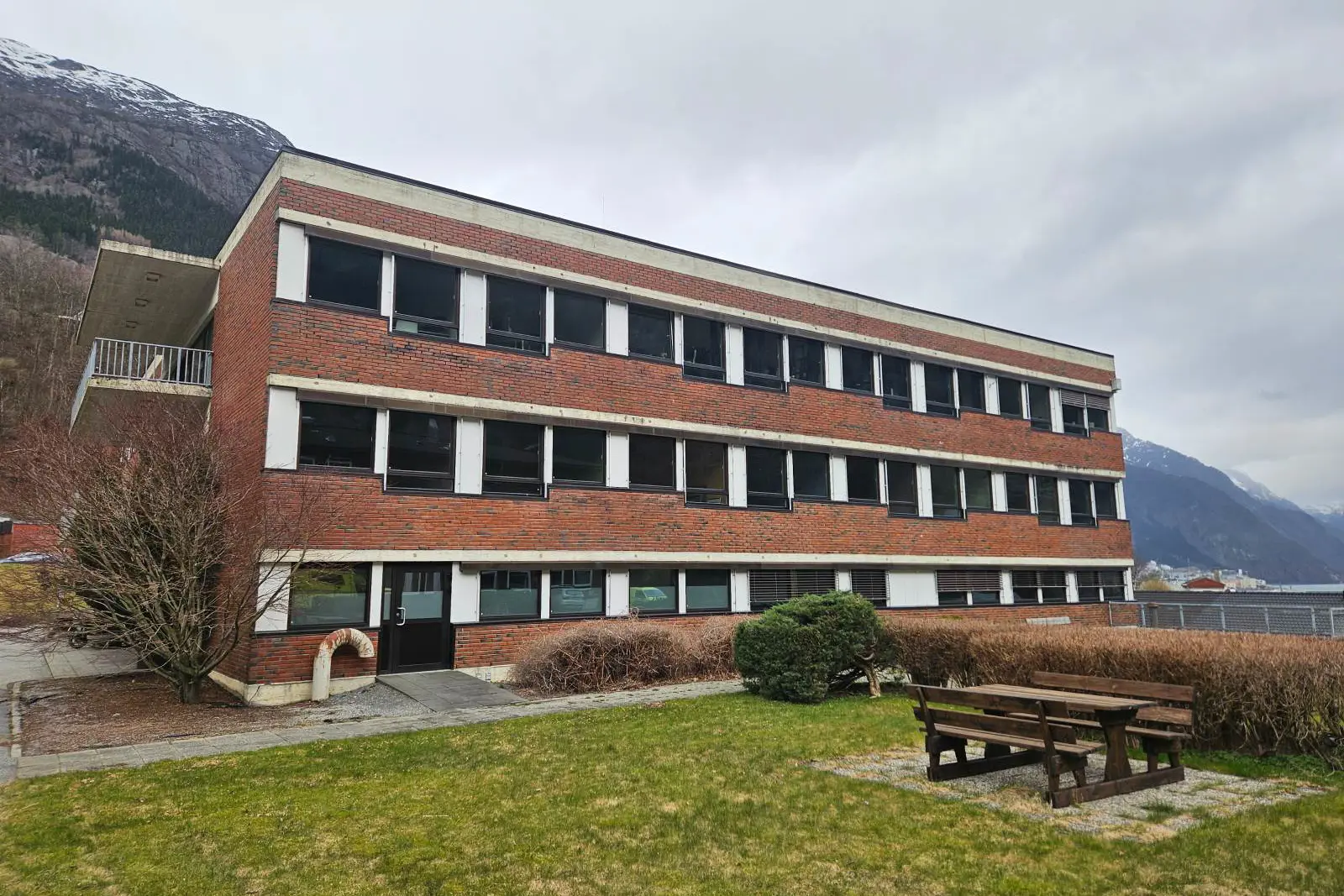 Ein bygning med ein benk foran