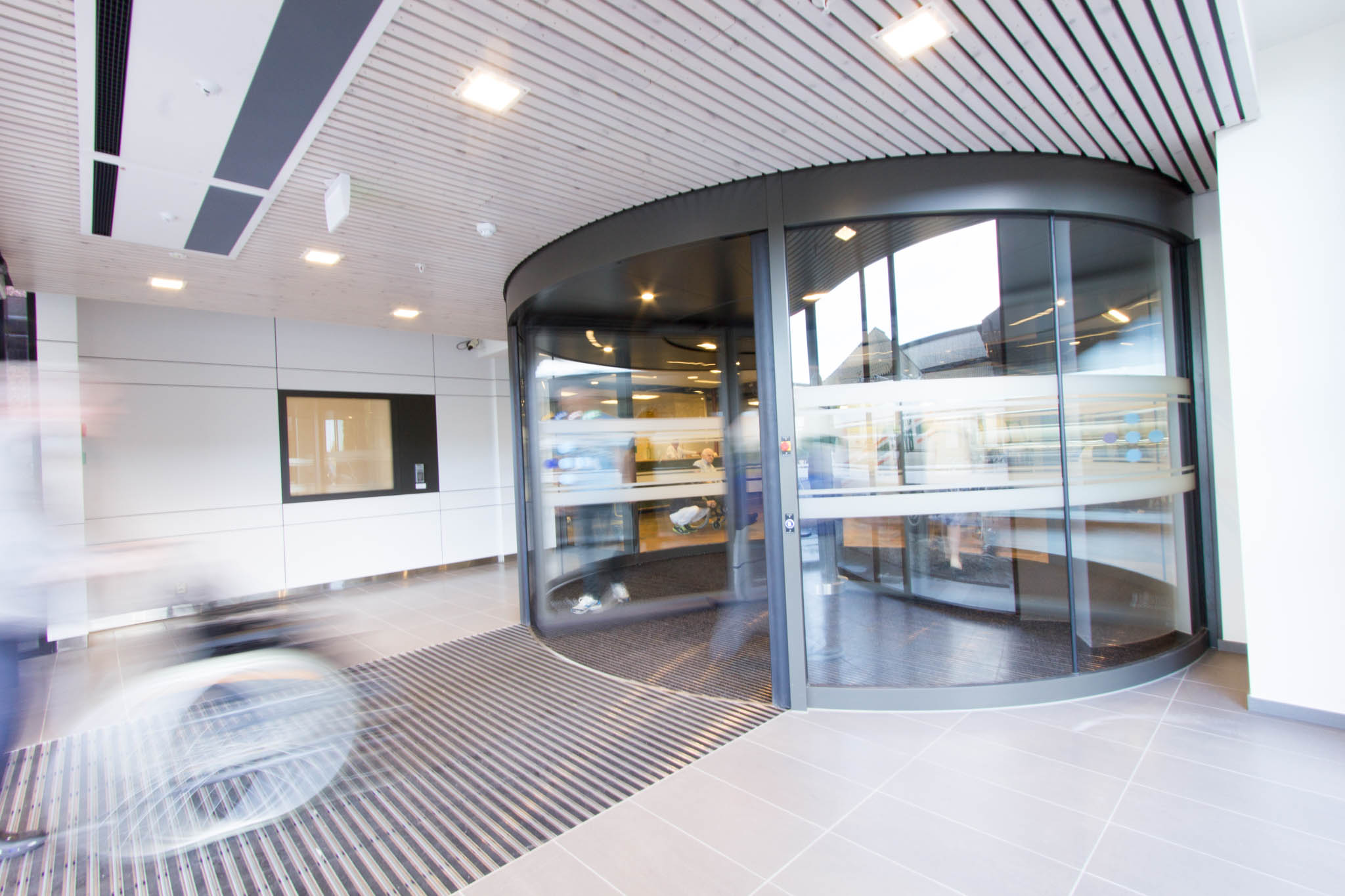 Et rom med glassvegger med glassdør og flisegulv