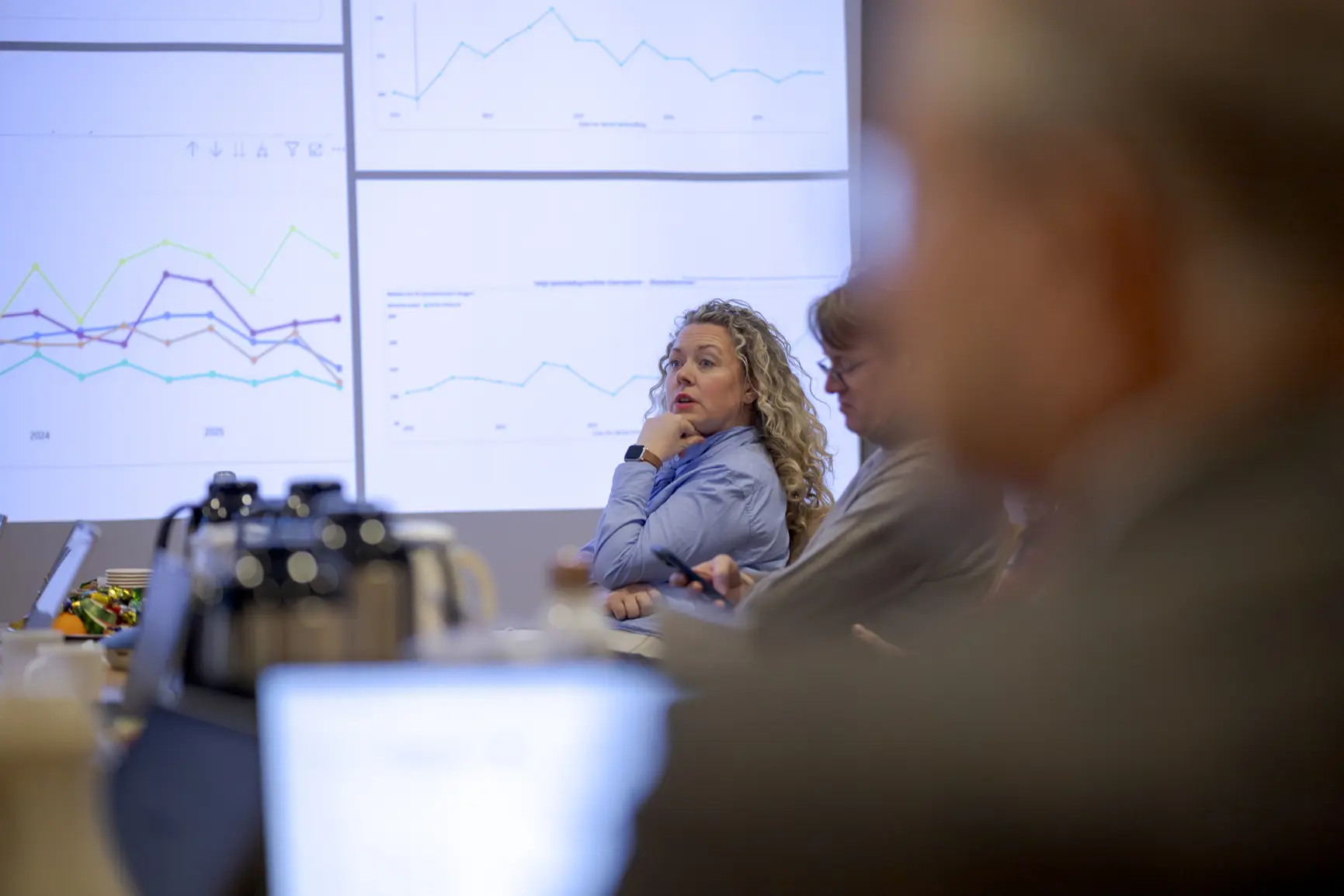 En kvinne og en mann som ser på en projektorskjerm