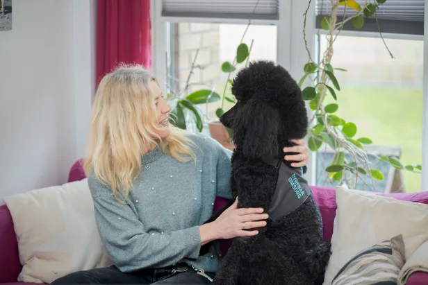 En kvinne som holder en hund