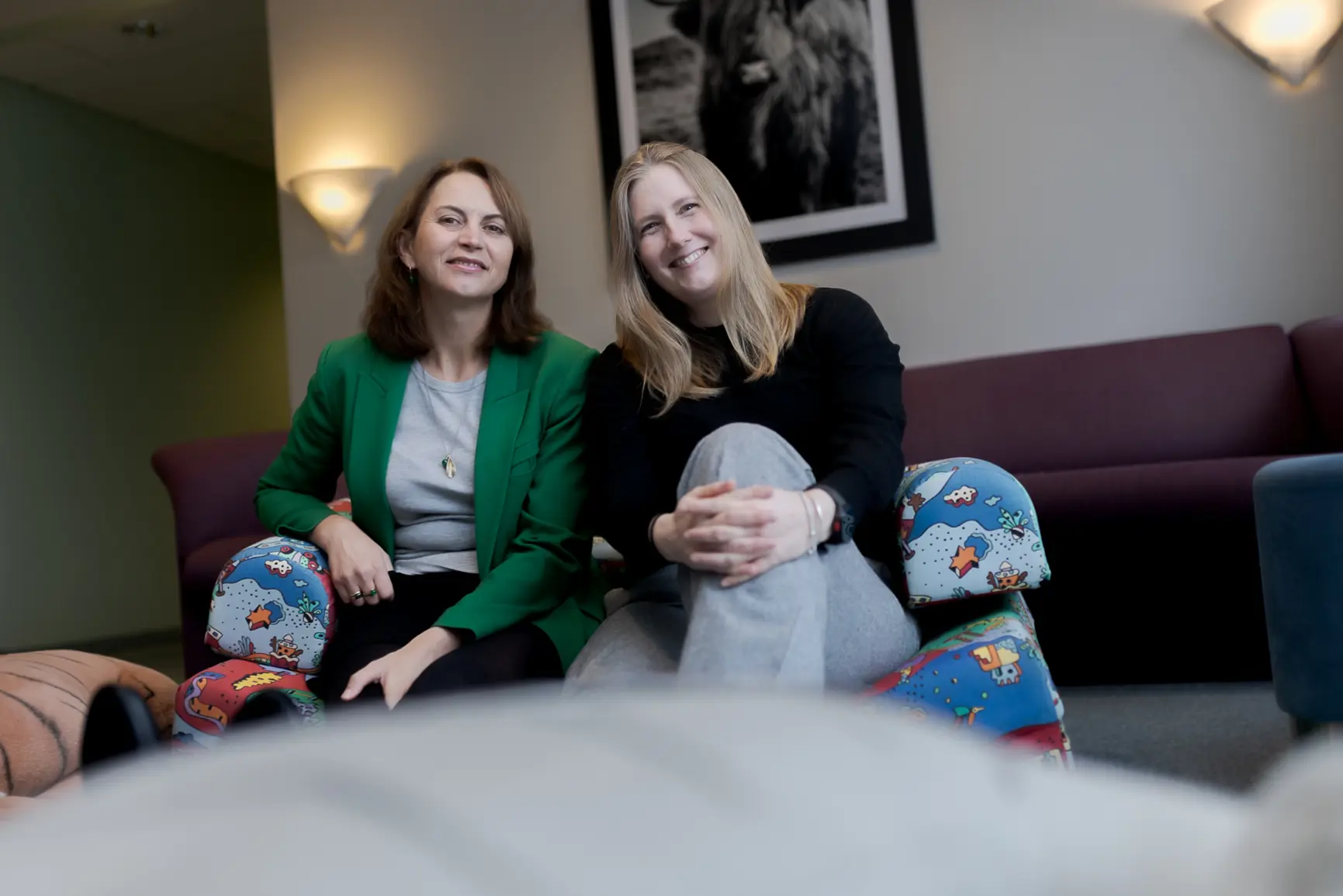 Et par kvinner som sitter på en sofa