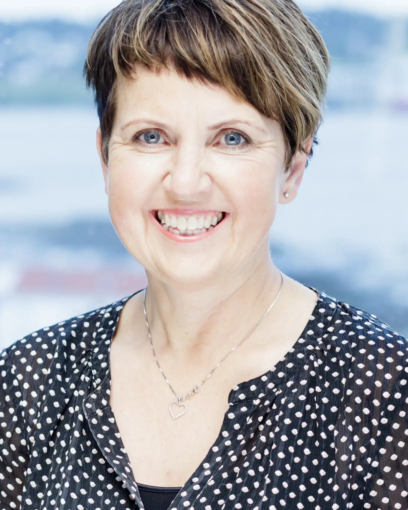 En kvinne som smiler til kameraet