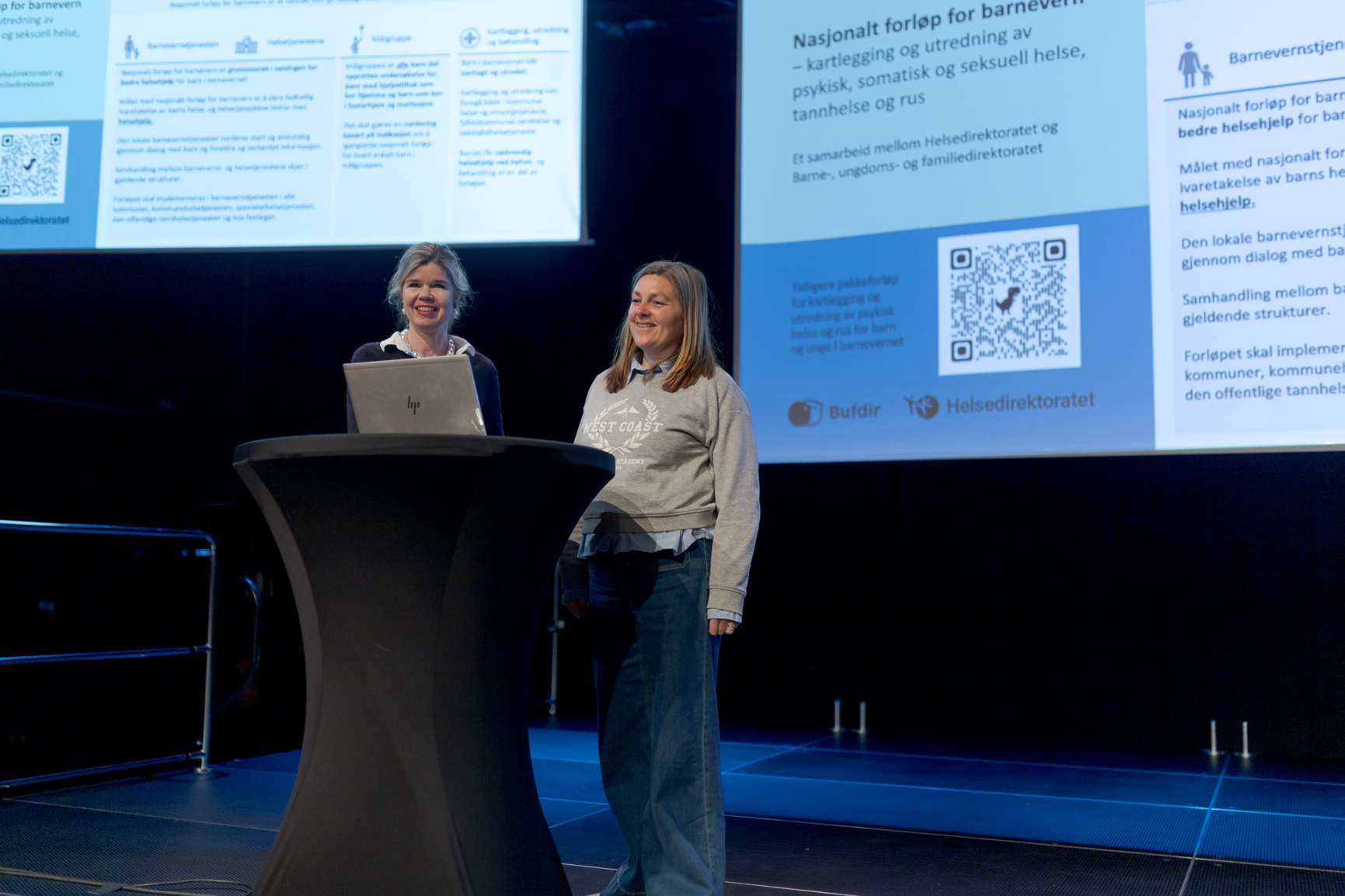 En person som står foran et podium med en person som sitter bak