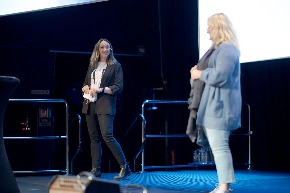 Et par kvinner som står på en scene