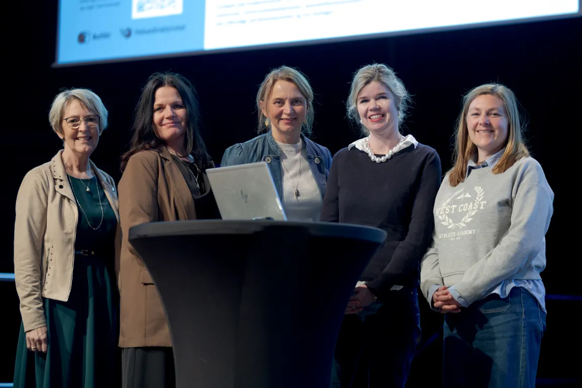 En gruppe kvinner som står foran en datamaskin