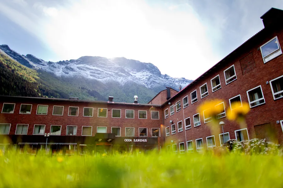 A brick building with a mountain in the background