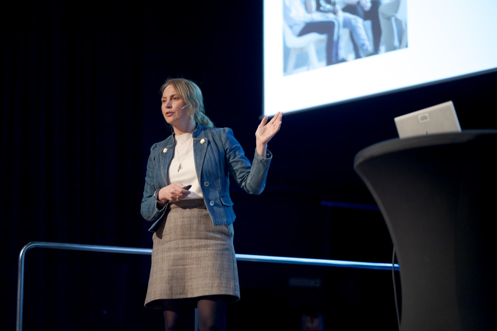 En person som står foran en talerstol med en laptop på