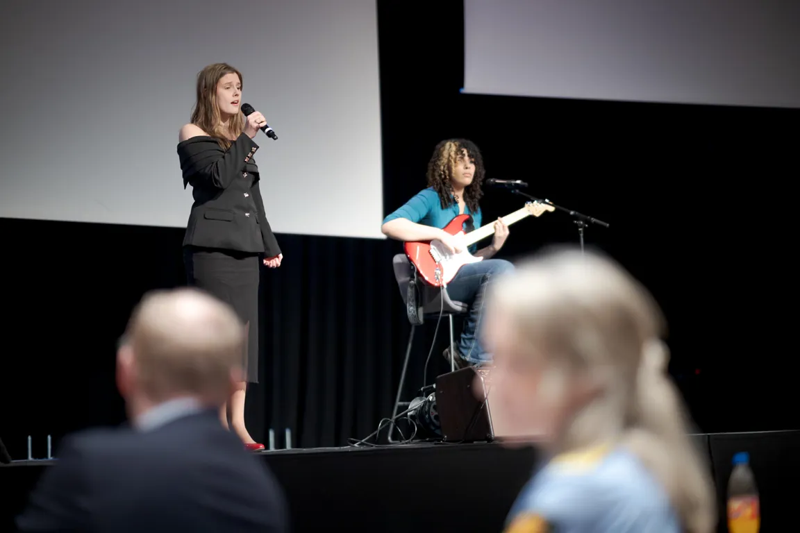 En person som synger inn i en mikrofon