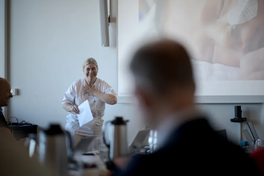 En kvinne som står foran en mann som sitter ved et skrivebord