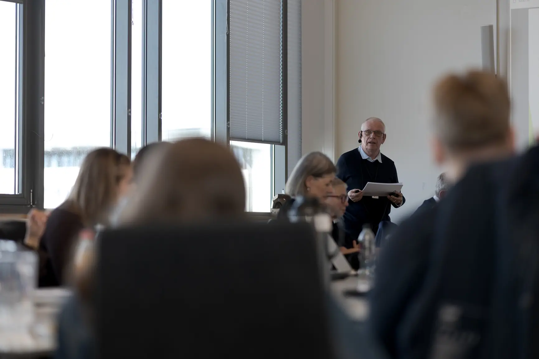 En person som snakker til en gruppe mennesker i et rom