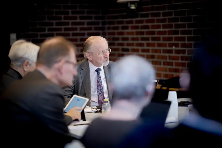 En gruppe menn som sitter i et rom