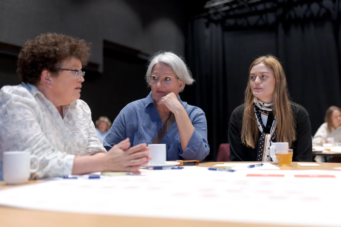 En gruppe mennesker som sitter ved et bord