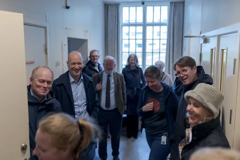 En gruppe mennesker som står i et rom