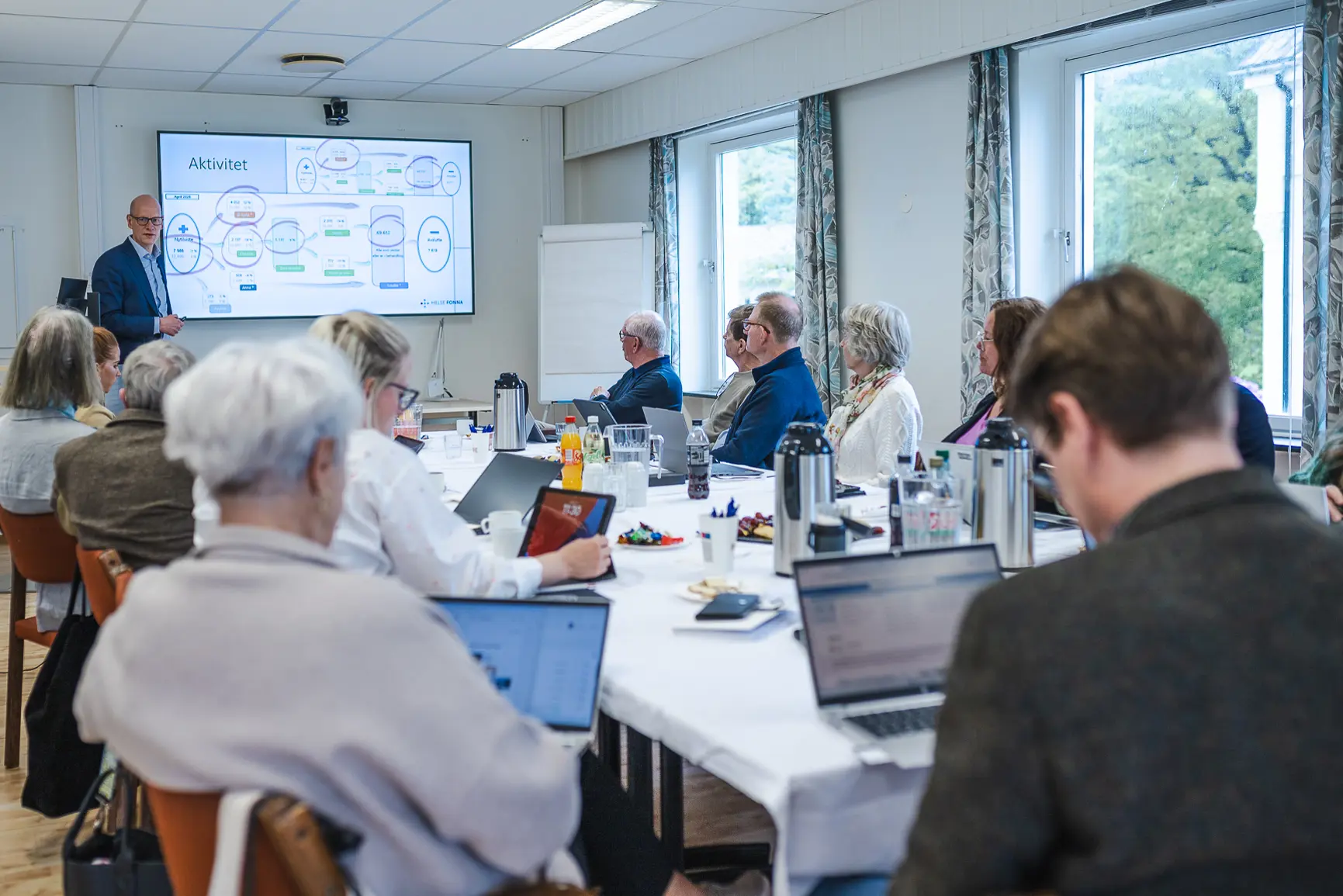 En gruppe mennesker som sitter rundt et bord med bærbare datamaskiner