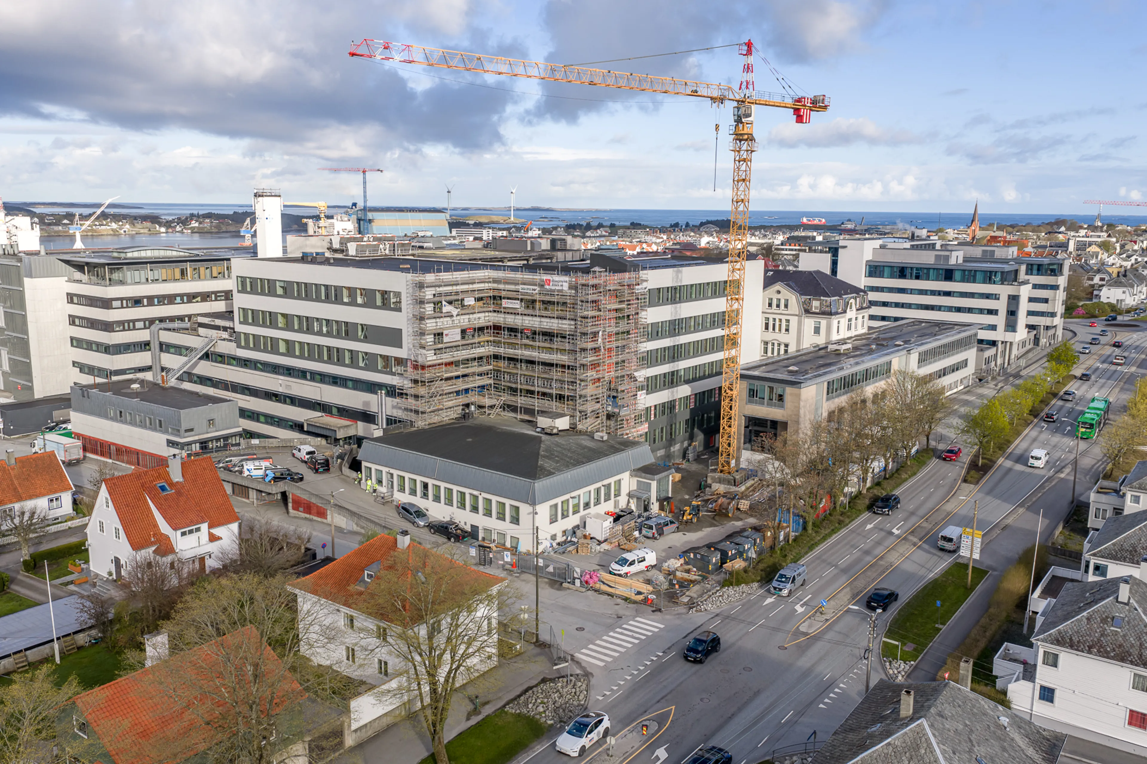 Ein stor bygning med byggekran i ein by