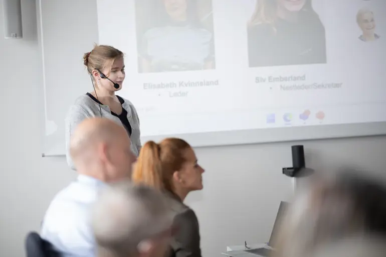 En person som snakker til en gruppe mennesker