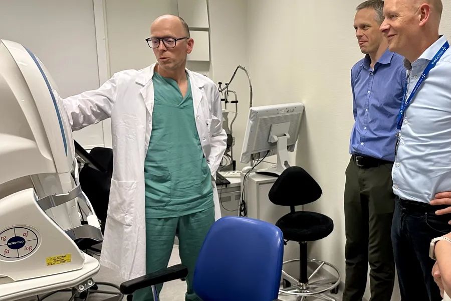 En gruppe menn som står ved siden av en medisinsk maskin