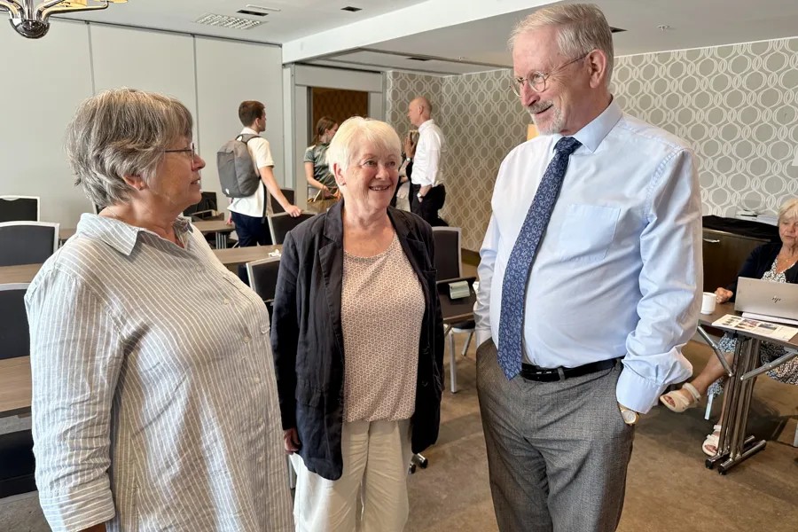 Noen få personer snakker på et kontor