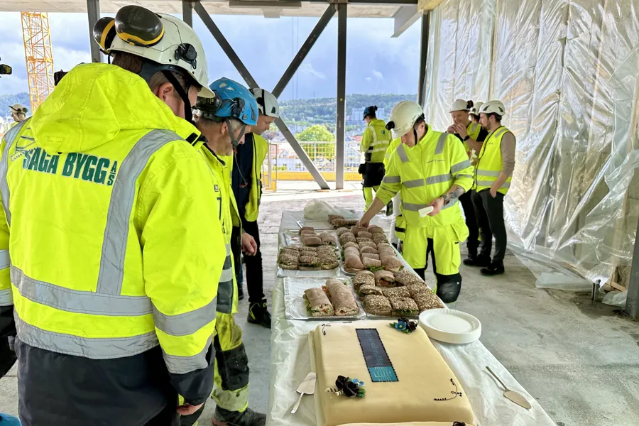 En gruppe mennesker i sikkerhetsvester som står rundt et bord med mat