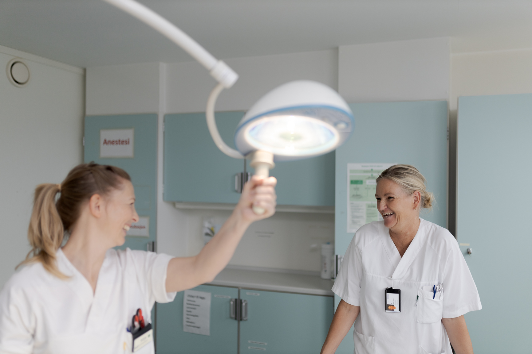En person i hvit laboratoriefrakk som holder en lyspære