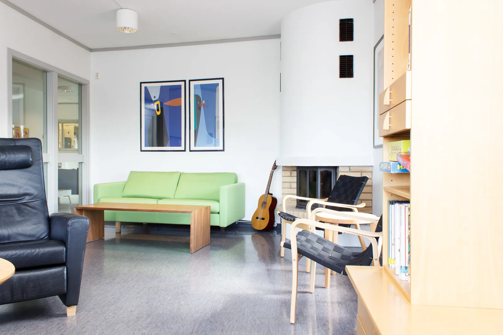 Et rom med sofa og bord med gitar
