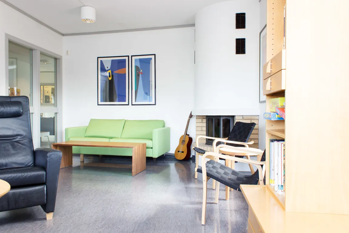 Et rom med sofa og bord med gitar