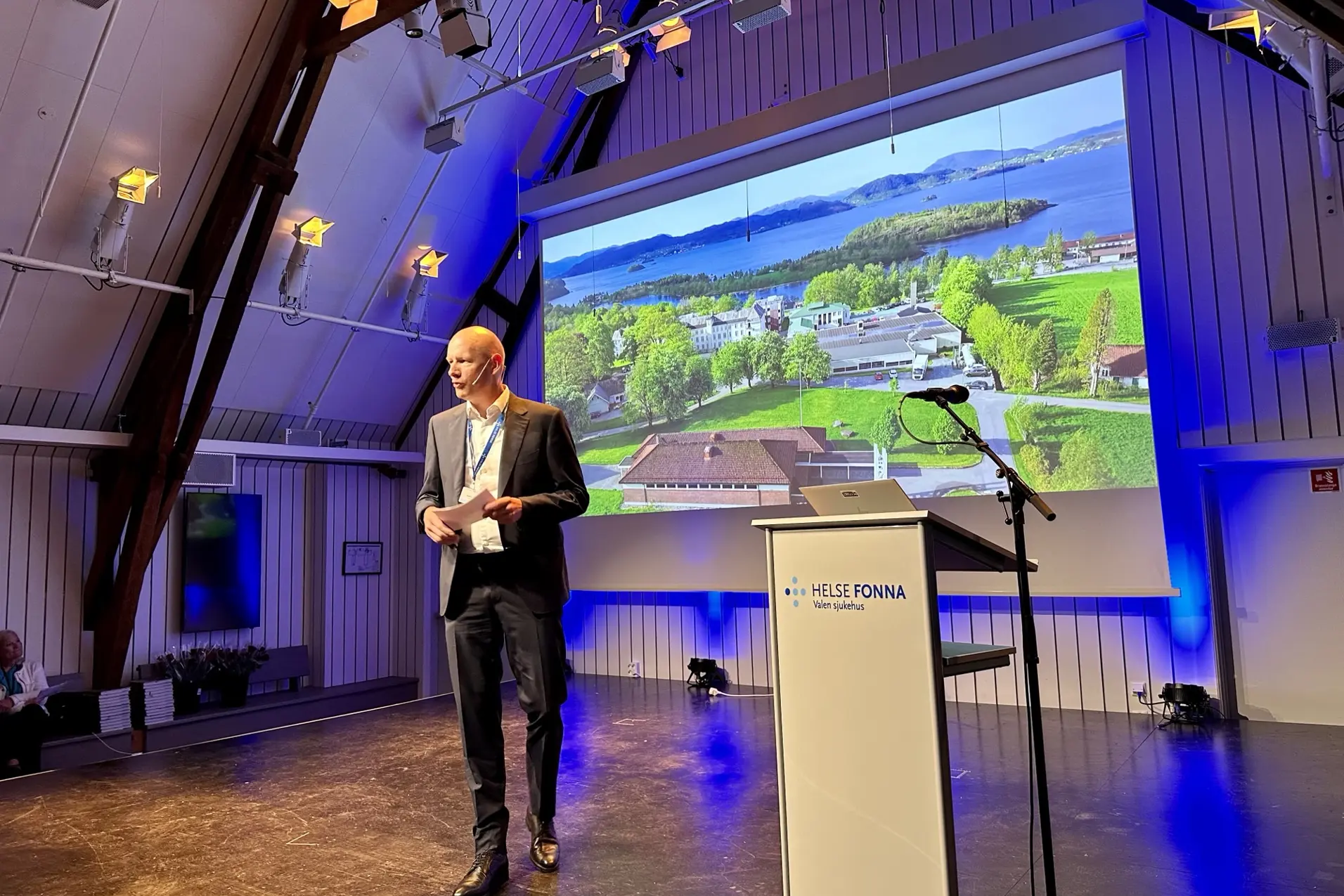 En person som står foran en stor skjerm