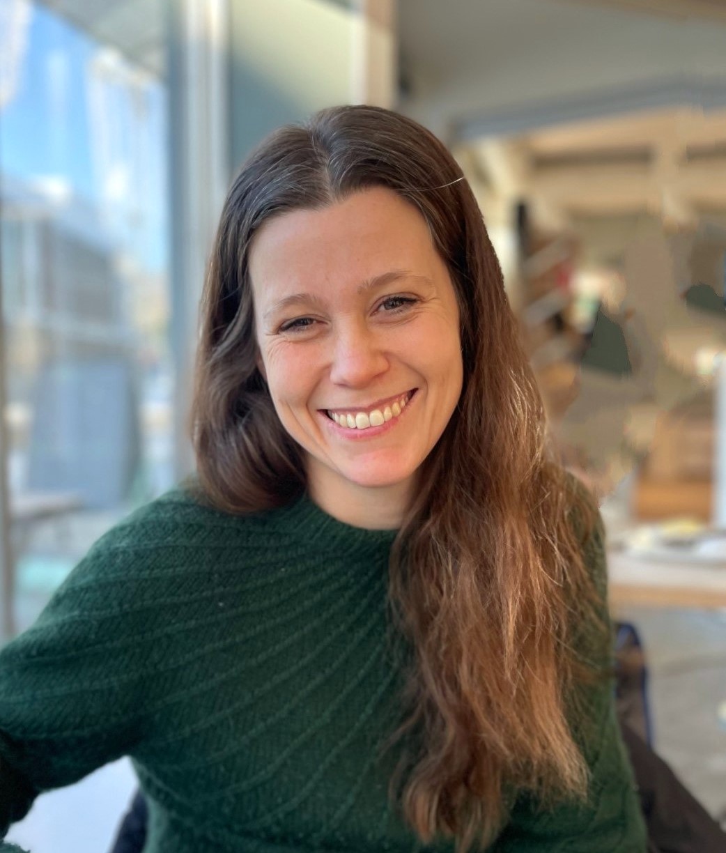 En kvinne som smiler til kameraet
