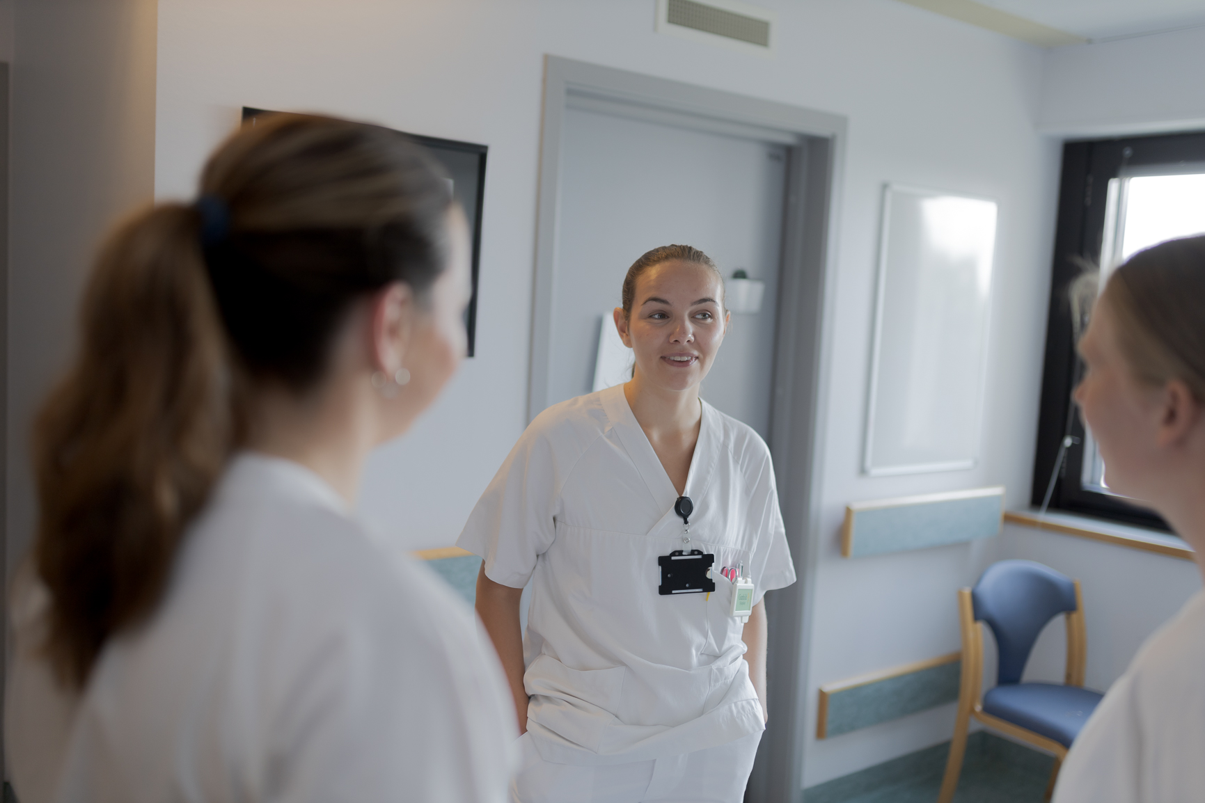 Tre sykepleiere snakker sammen