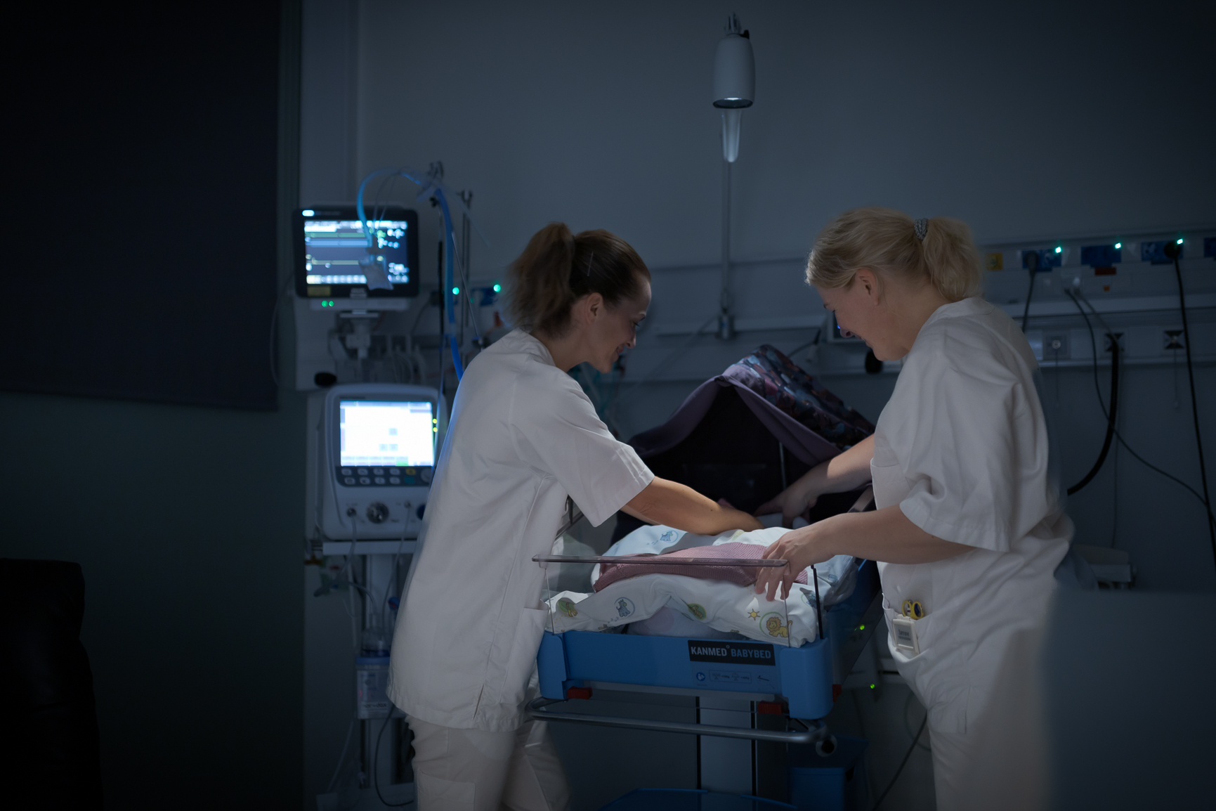 To sykepleiere står foran en kuvøse