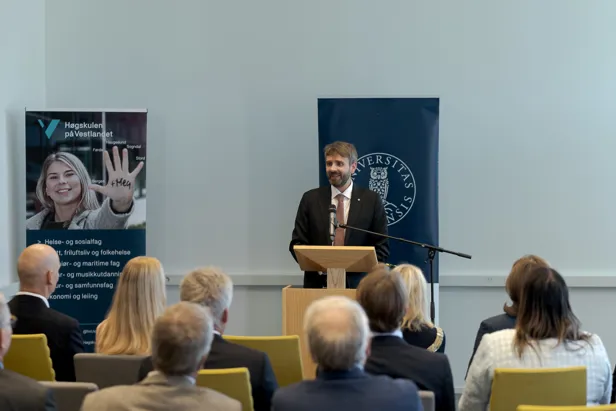 En person som står på et podium foran en gruppe mennesker