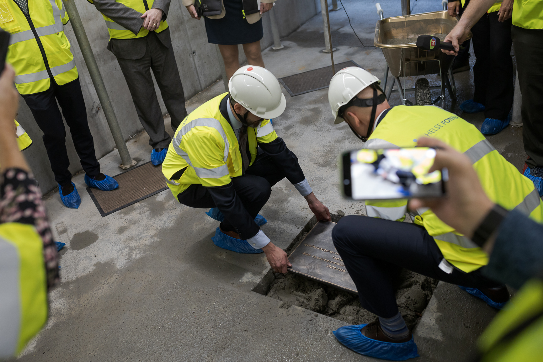 En gruppe mennesker i sikkerhetsvester som jobber på et rør