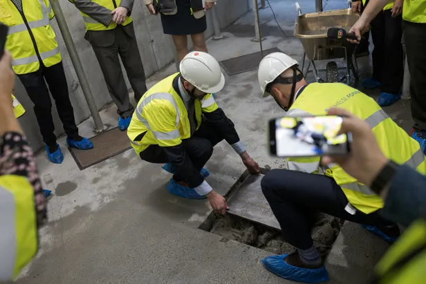 En gruppe mennesker i sikkerhetsvester som jobber på et rør