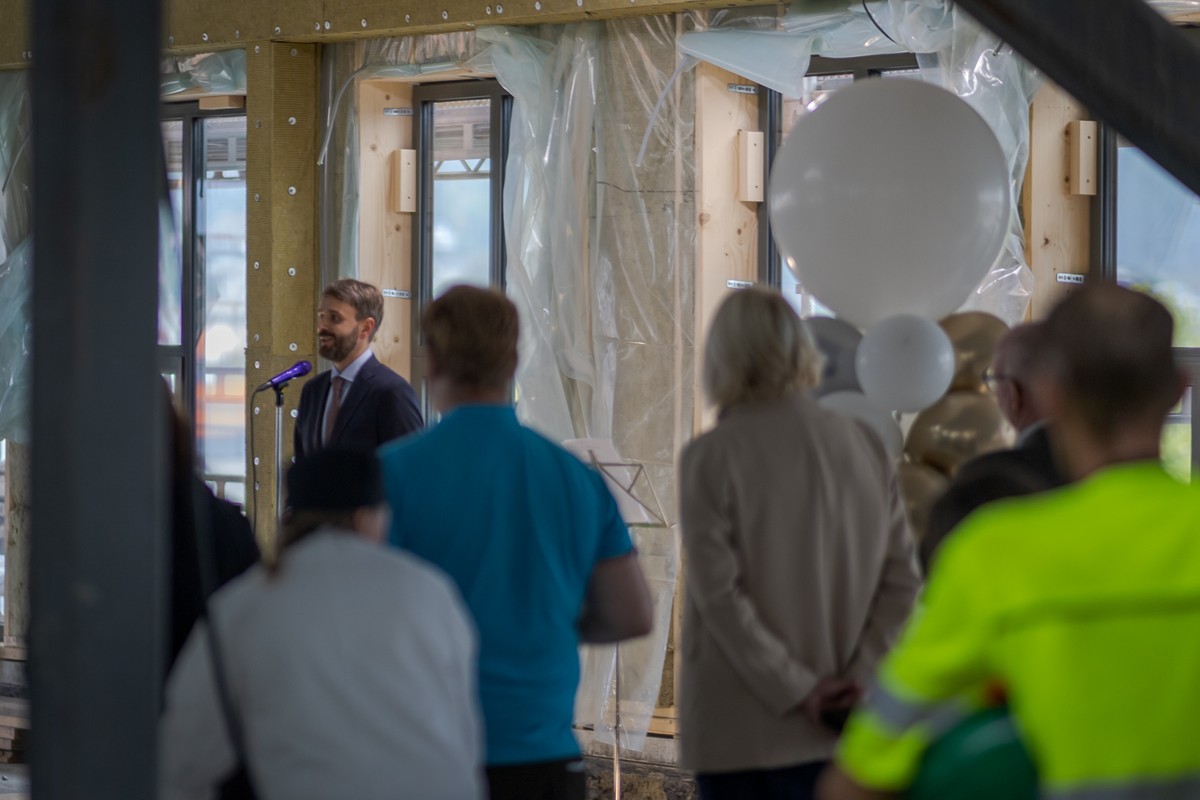 En gruppe mennesker som står i et rom med ballonger