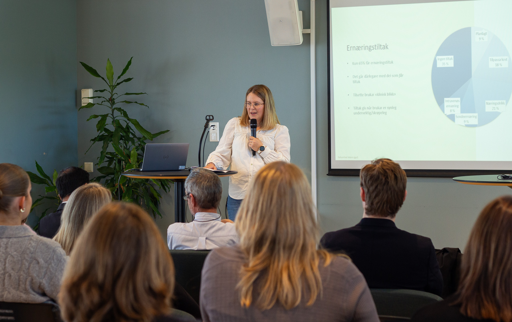 En person som snakker til en gruppe mennesker